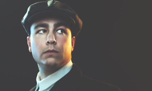 Man looking off in the distance wearing 1920's-style clothes. Click to discover the Liverpool Peaky Blinders tour: