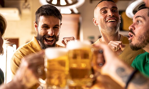 An image of five men enjoying a large pint of beer.