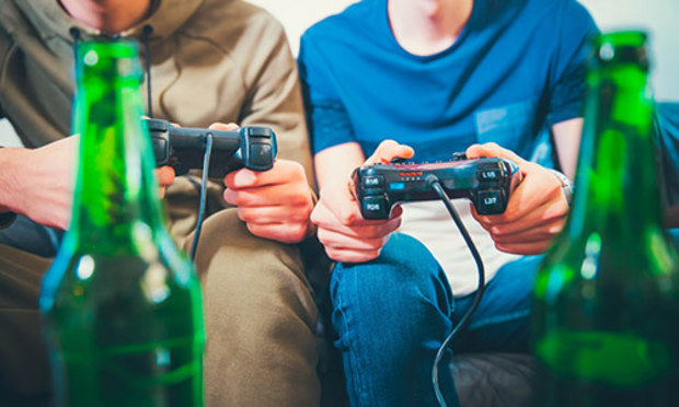 Guy playing xbox and drinking beer