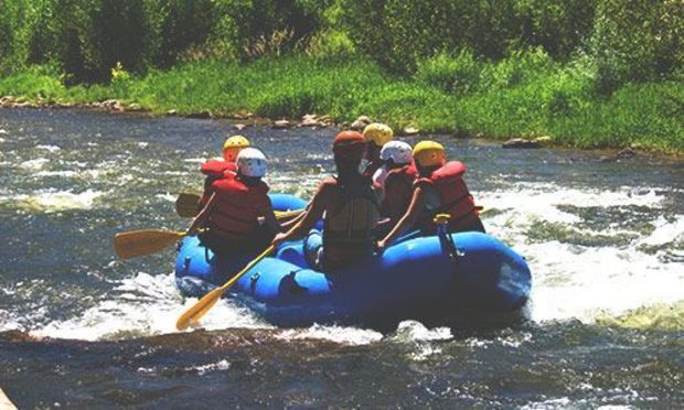 Guys enjoying river rafting on stag weekend 