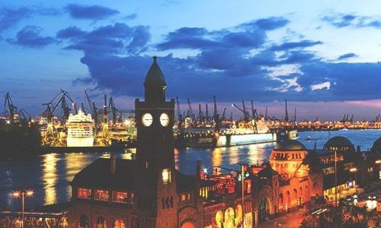 View over the clock tower and the Elbe River at sundown. Discover Hamburg Stag Party ideas below: