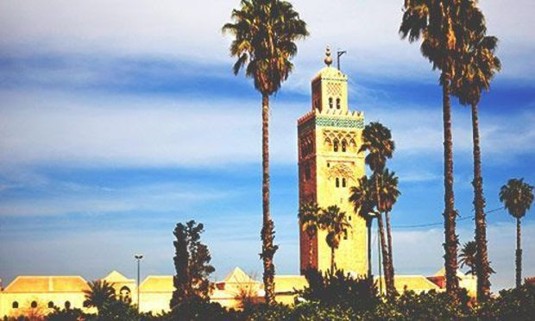 Sun shining on the Koutoubia Mosque with wispy clouds in the sky. Explore Marrakech Stag Party ideas below: