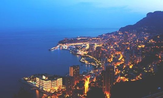 Aerial view of Monte Carlo lit up at night. Explore Monte Carlo Stag Party ideas below: