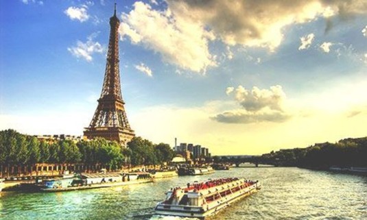 River boats cruising up the River Seine next to the Eiffel Tower. Explore Paris Stag Party ideas below: