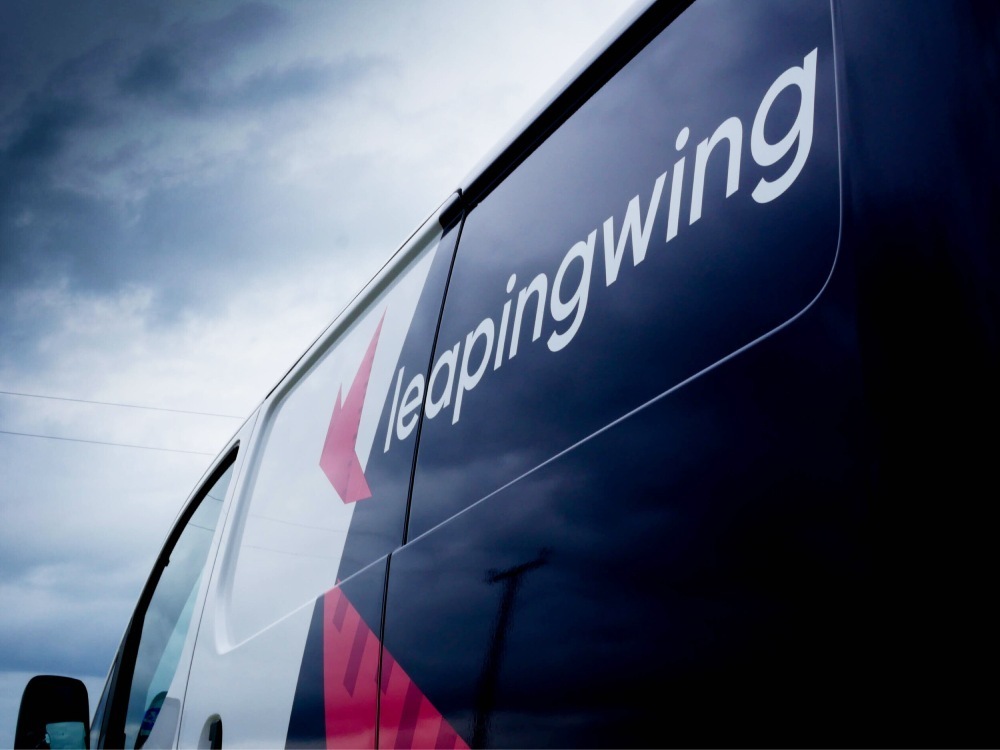 Leaping Wing branded vinyl van wrap on Nissan enV200.