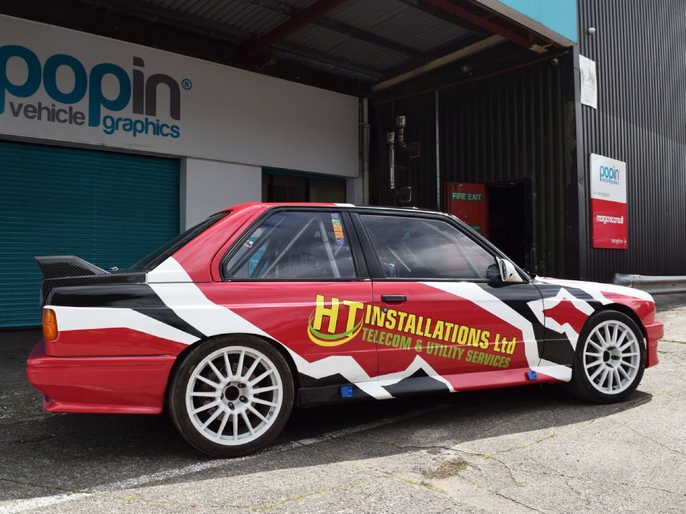 BMW E30 with company branded wrap and graphics outside Popin in Cardiff.