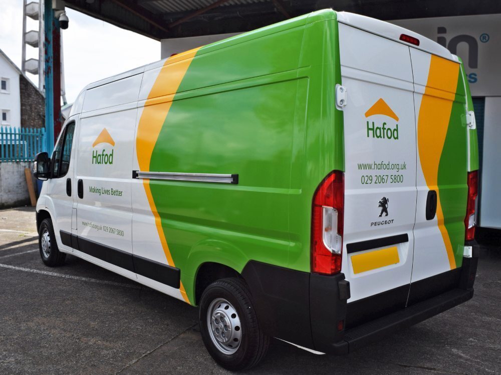 Branded green and yellow partial van wrap and graphics on white company Peugeot Boxer.