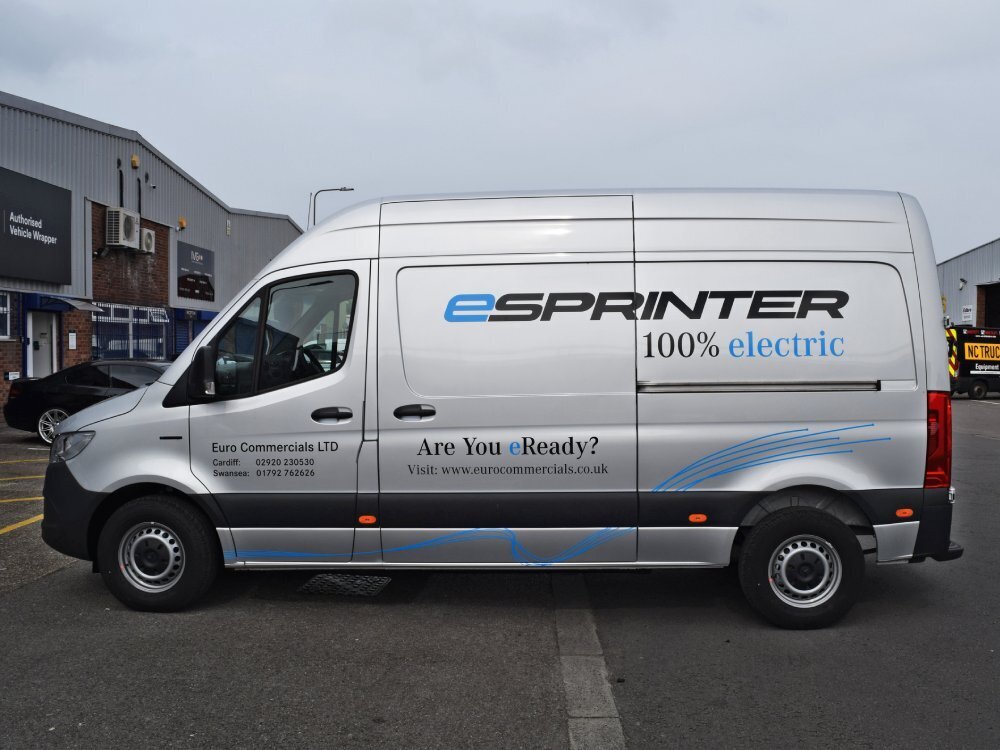 Silver Mercedes eSprinter with branded vinyl van graphics.