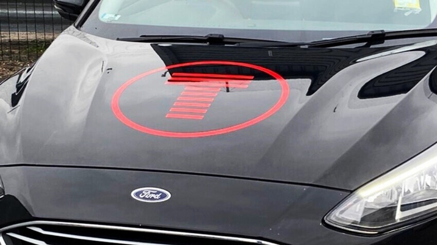 Ford Focus company car with business logo vinyl graphics on bonnet.