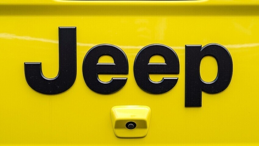 Jeep emblem on a yellow vehicle.