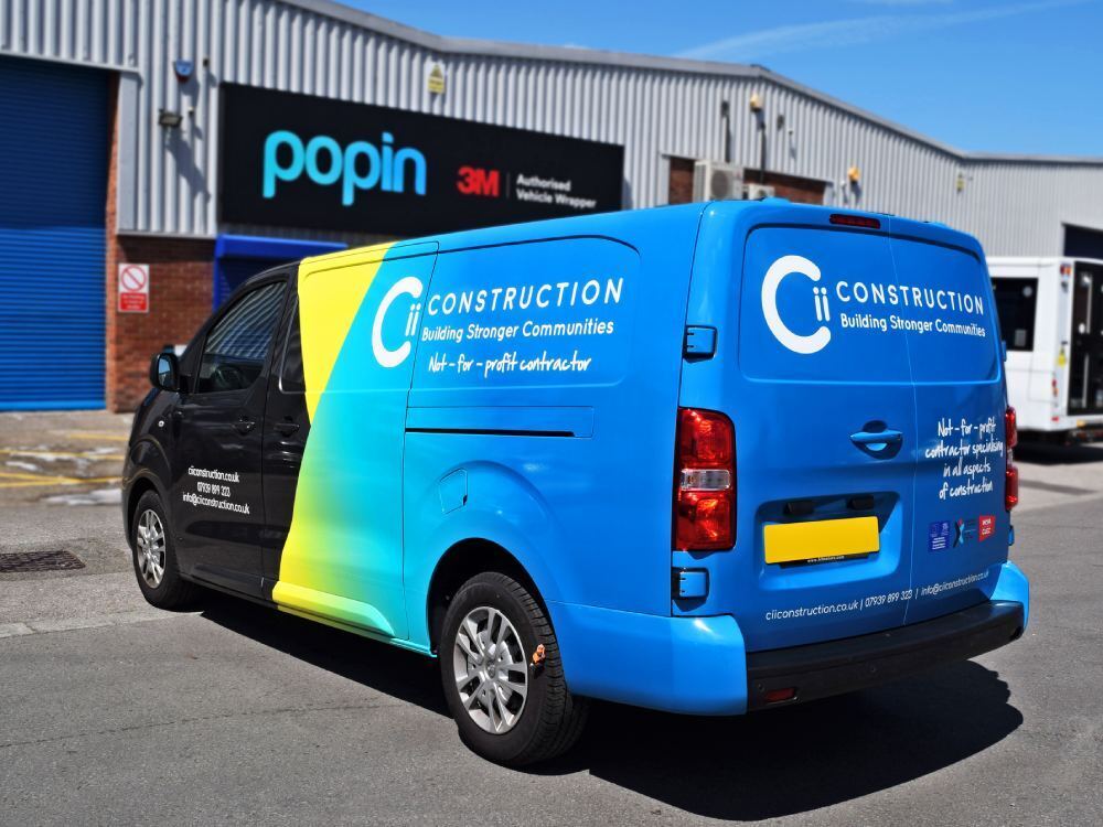Blue and yellow partial advertising van wrap on Vauxhall Vivaro outside Popin in Cardiff.
