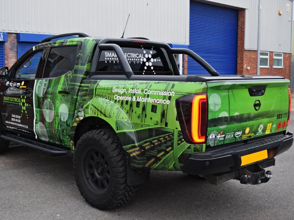 Company branded green reflective vehicle livery on Nissan Navara.