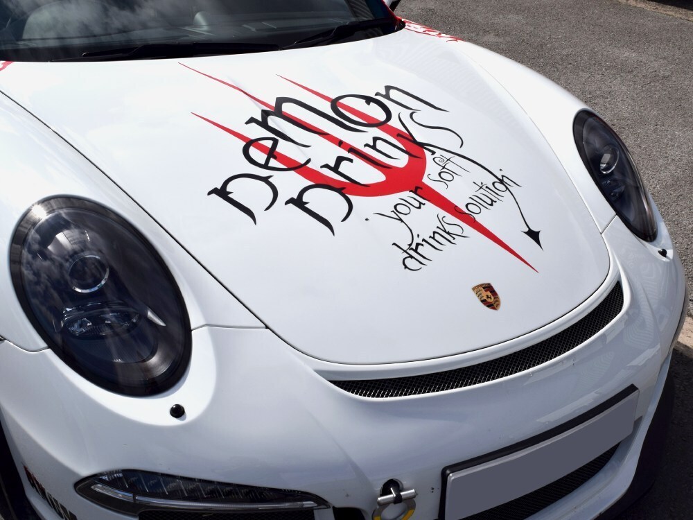Demon drinks race car graphics on bonnet of a white Porsche GT3 RS