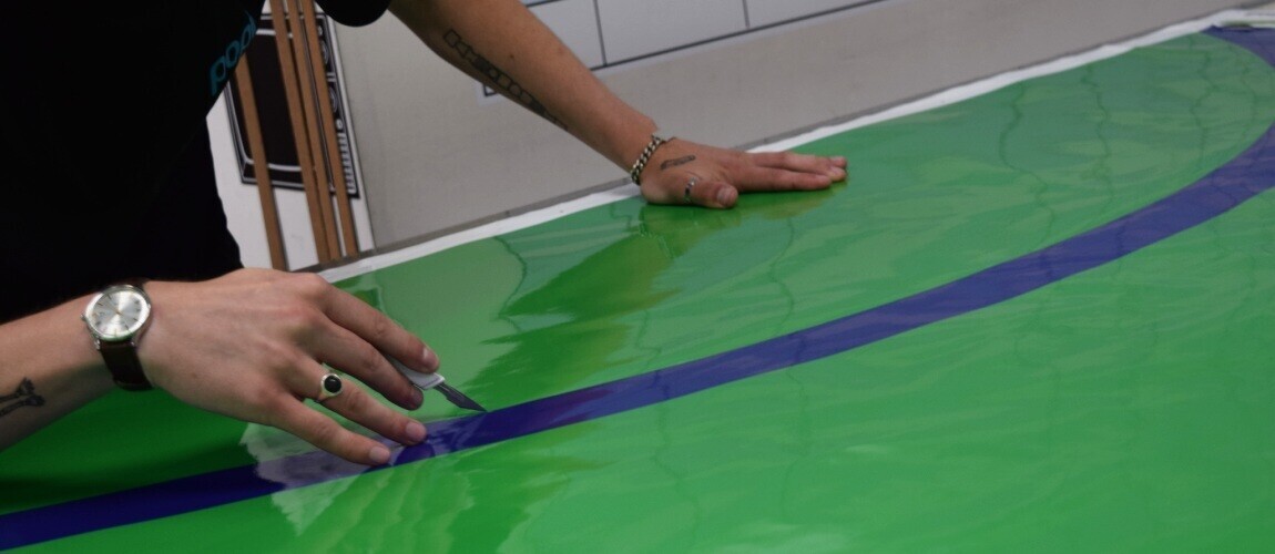 Vinyl graphic outline being carefully cut out after being printed.