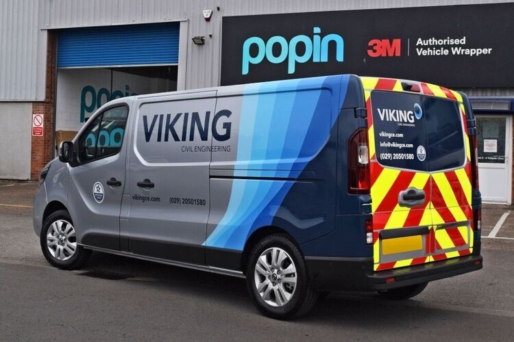 Silver Nissan NV300 with business branded partial van wrap and rear safety chevron graphics outside Popin in Cardiff.