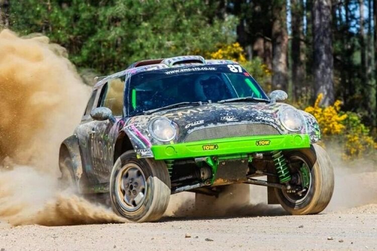Mini Cooper V6 rally car with colourful motorsport livery and graphics during race