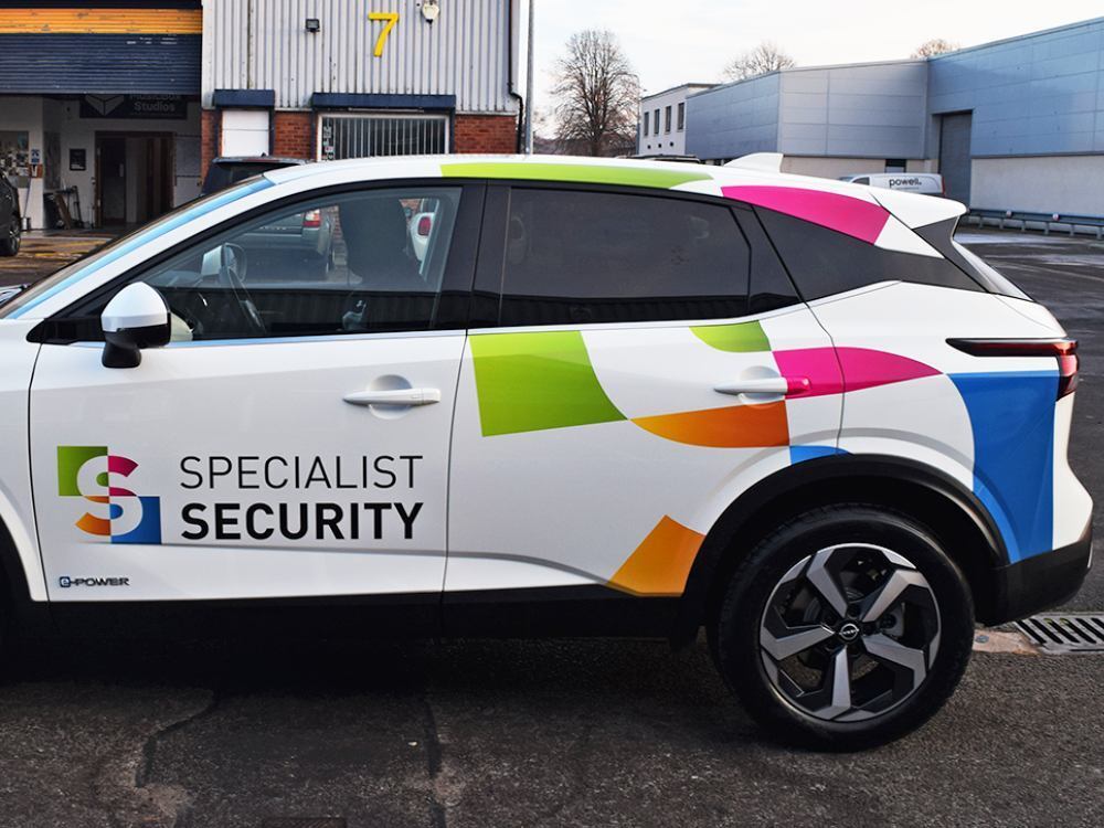 Company Nissan Juke with bright branded graphics and vehicle wrap.