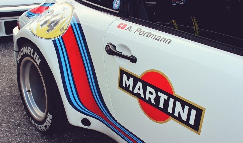 Martini motorsport sponsored livery on white race car.