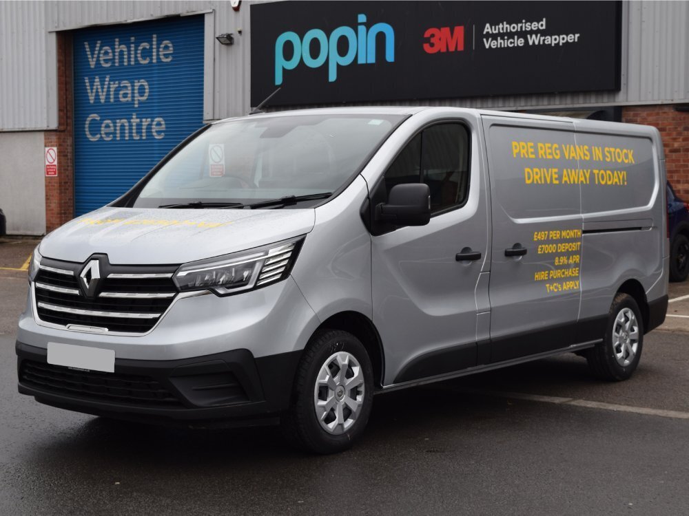 Silver Renault Trafic van with yellow vinyl graphics.
