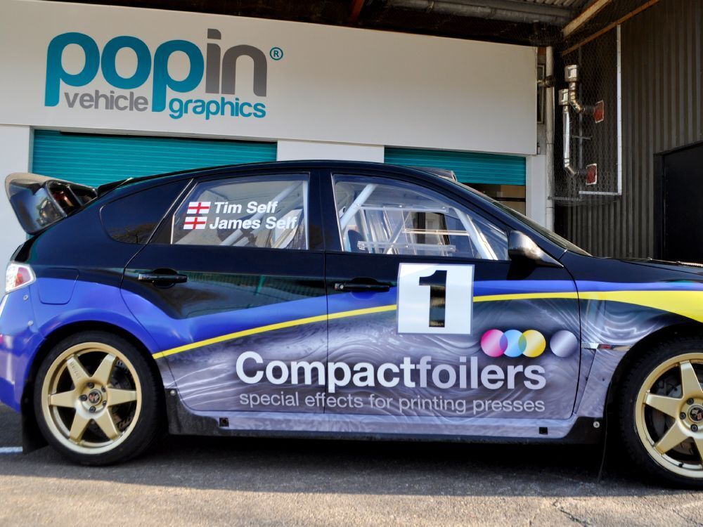 Race livery and graphics on side of a Subaru Impreza B13 rally car