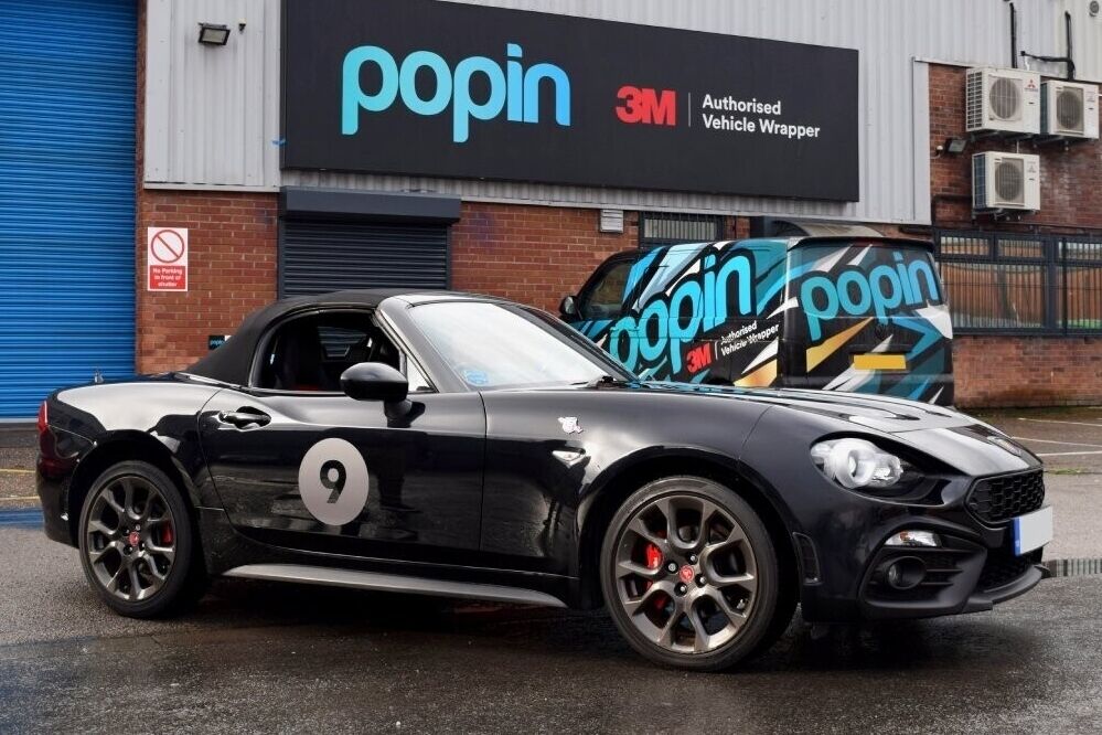 Arbath 124 spider with a motorsport vehicle wrap and vinyl graphics parked outside Popin in Cardiff.