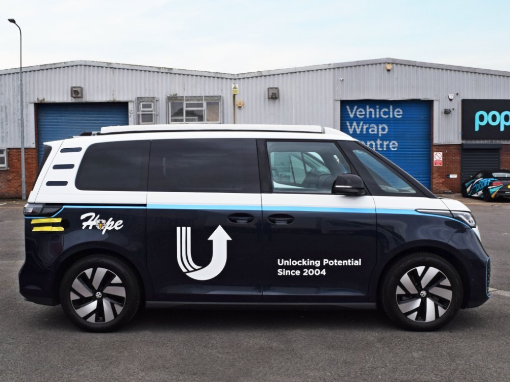 Partial van wrap and company branded graphics on Volkswagen ID. Buzz outside Popin in Cardiff.
