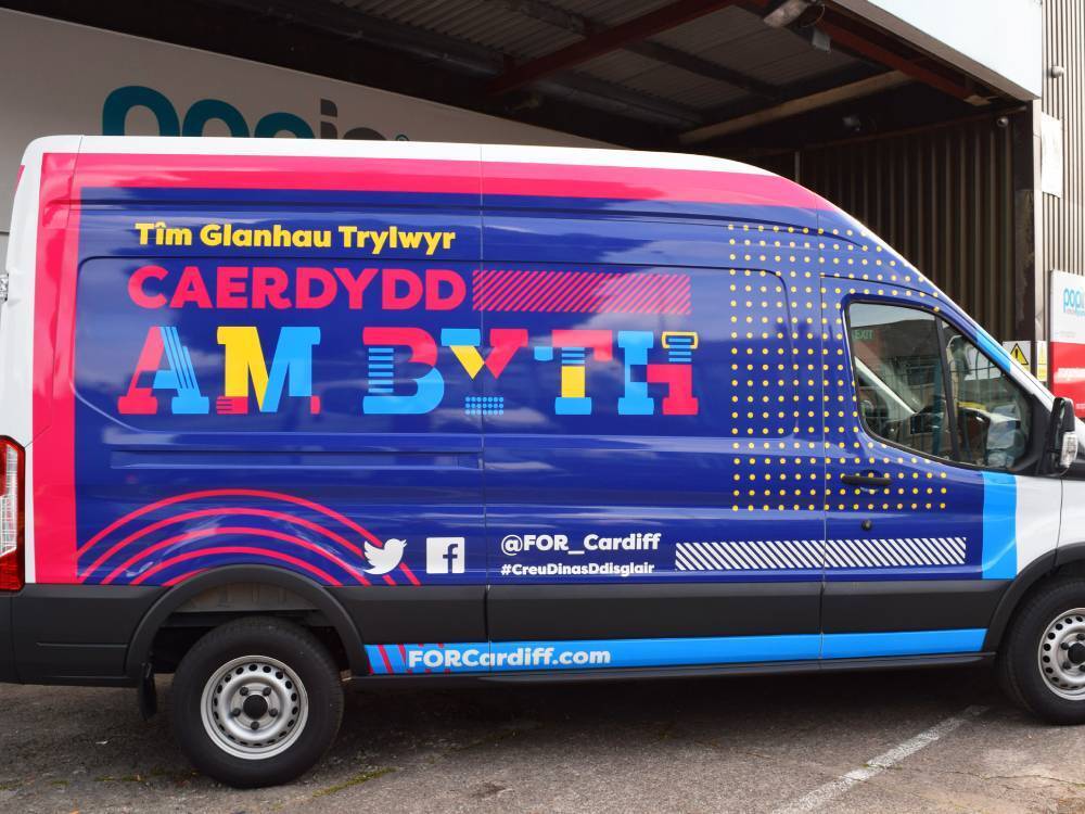 Colourful vehicle wrap on Ford Transit company van.