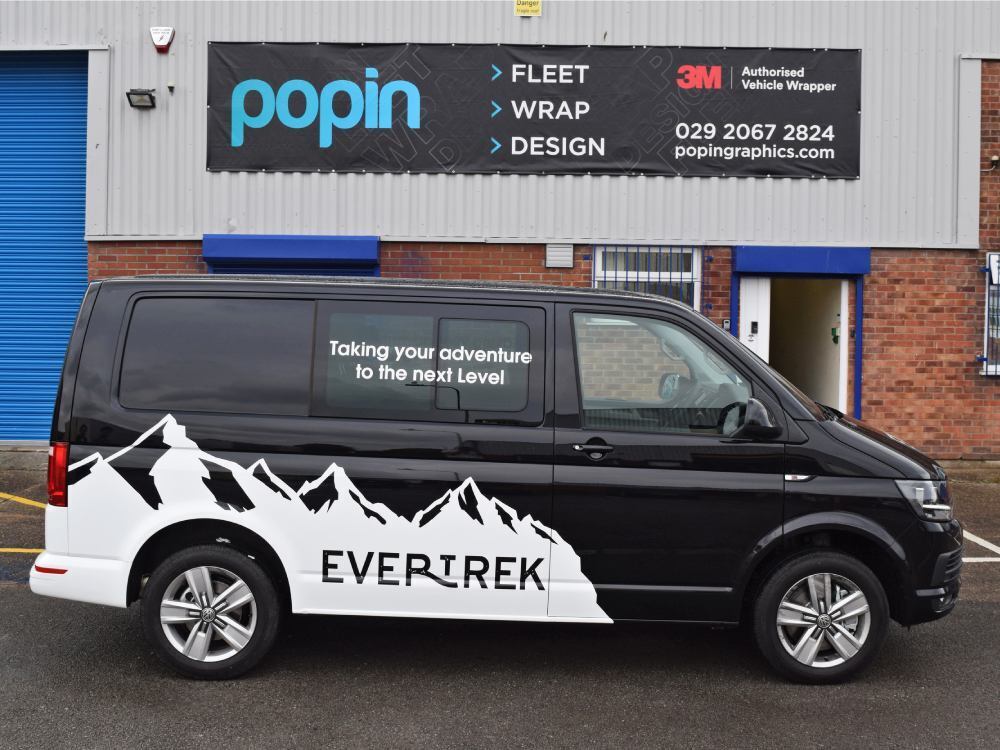 Black company Volkswagen Transporter with white mountain scene vinyl graphics outside Popin vehicle wrap centre in Cardiff.