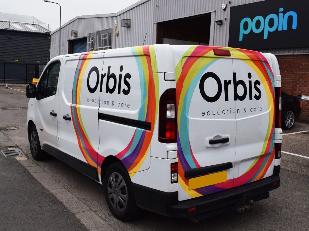 Colourful vehicle vinyl graphics on a white company Fiat Talento van.