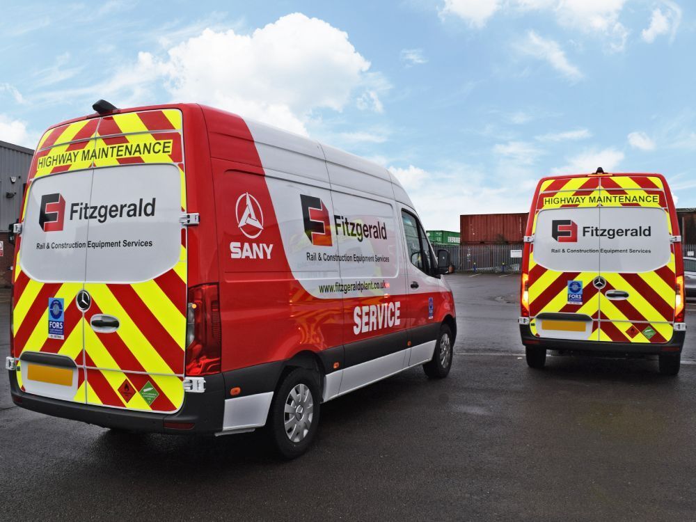 Two Mercedes Sprinter vans with rear chevron safety marking vinyl graphics and branded vehicle wraps.