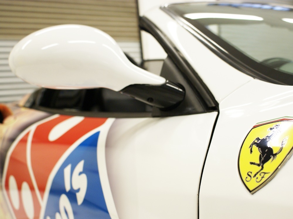 Close up of a Domino's Pizza car graphic on a white Ferrari 360 Spider.