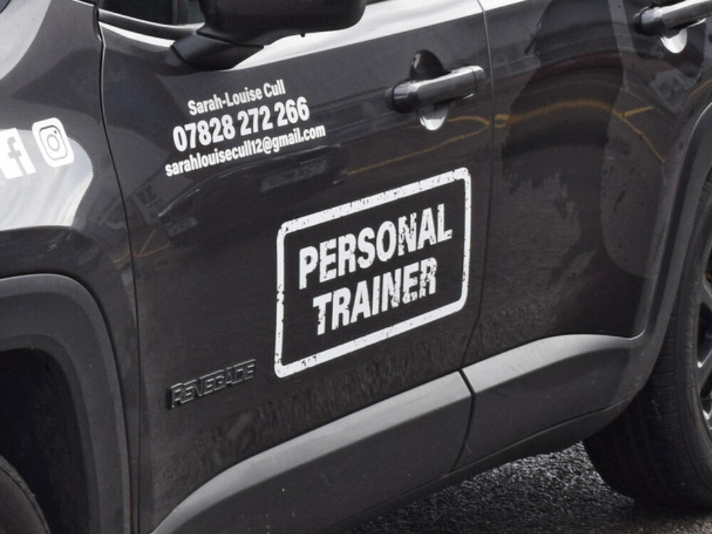 White company branded personal trainer vinyl graphics on grey Jeep.