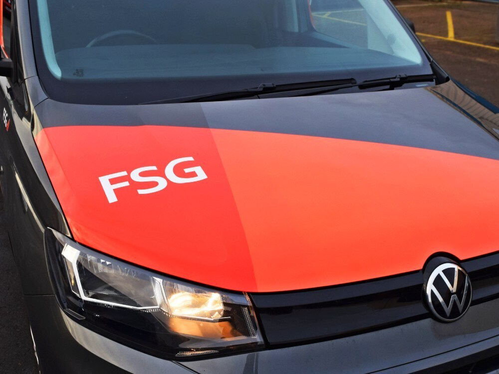 Vehicle wrap and branded vinyl graphics on bonnet of Volkswagen Transporter van.