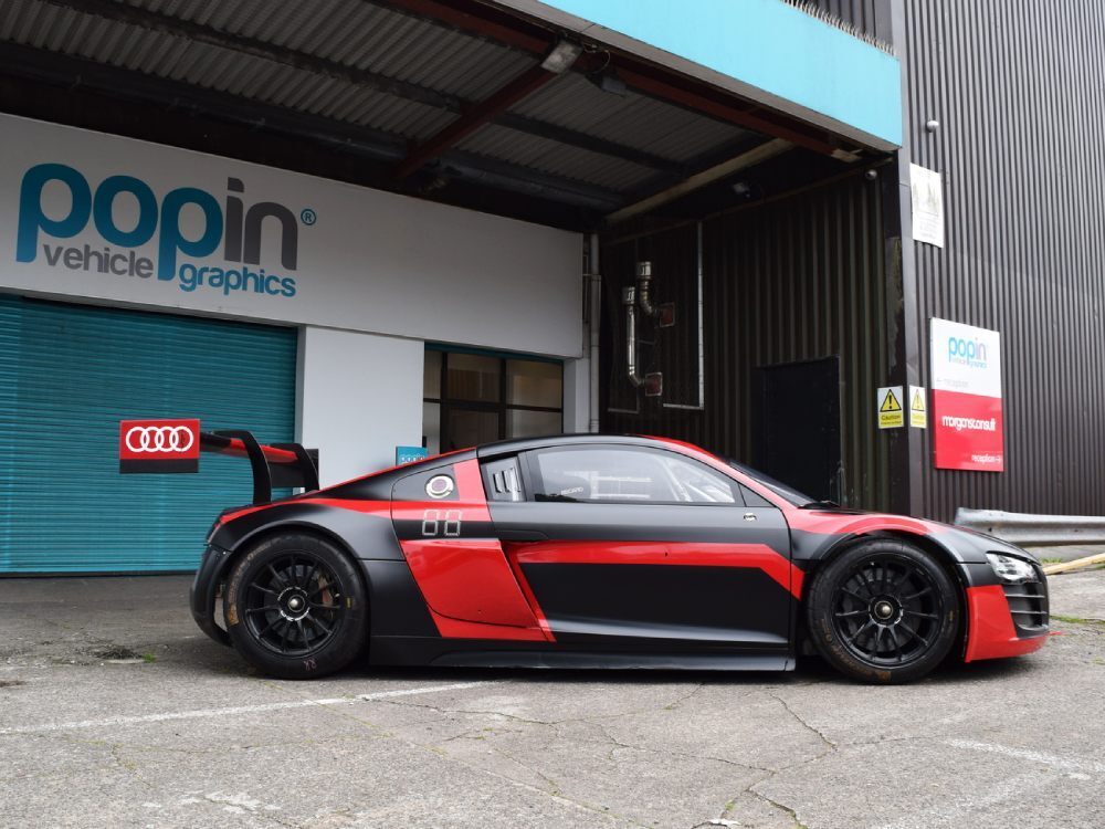 Red and black wrap and graphics on company Audi R8 LMS outside Popin in Cardiff.