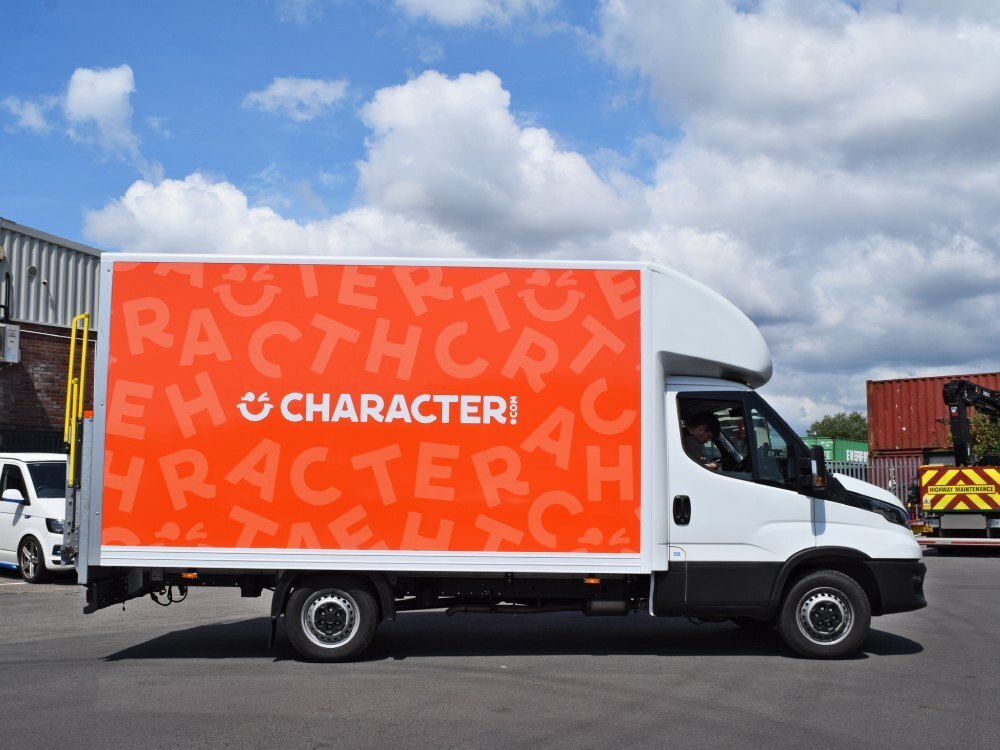 Partial orange character.com branded vehicle wrap on Iveco Daily Box van.