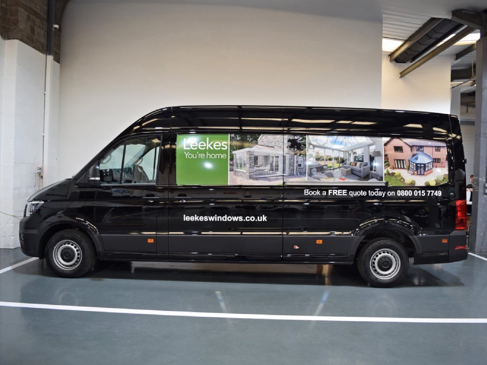 Leekes infilled panel graphics on side of black Volkswagen Crafter.