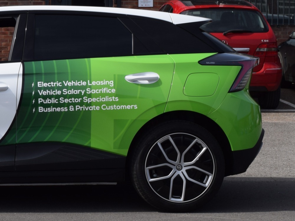 Green partial car wrap on rear of company MG4 Trophy EV.
