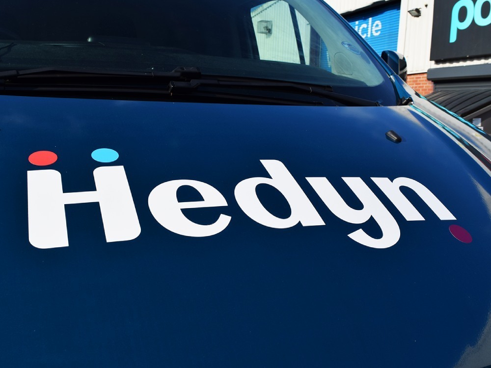 Hedyn branded vehicle graphics installed on front end of company Ford Transit van.