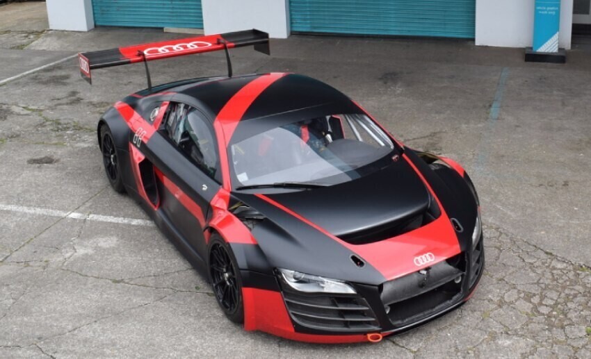Red and black full vehicle livery and graphics on an Audi sports car parked outside Popin in Cardiff.