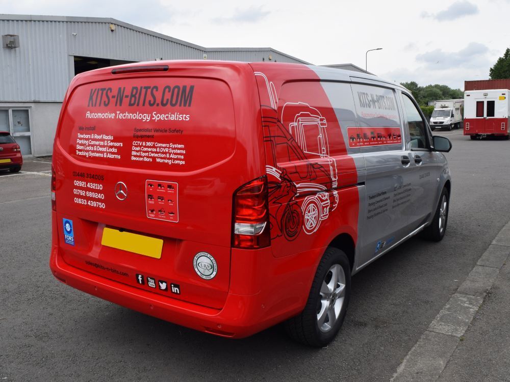 Silver Mercedes Vito van with red company branded partial vehicle wrap.