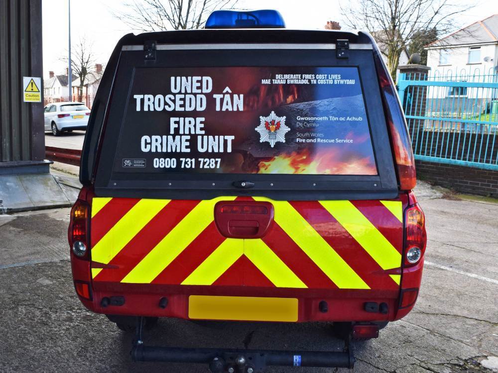 Red and yellow chevrons and rear window graphics on South Wales Fire Mitsubishi L200.