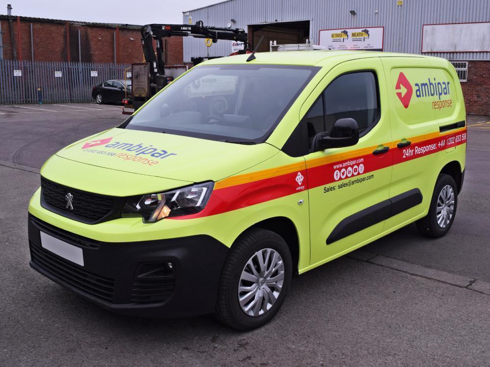 Bright yellow fluorescent van wrap on Peugeot Partner vehicle.