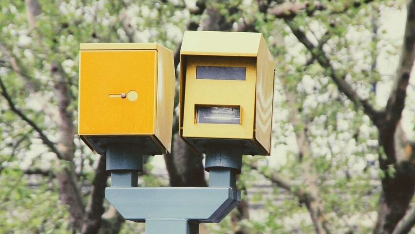 Yellow speed cameras with built-in ANPR technology on UK roadside.
