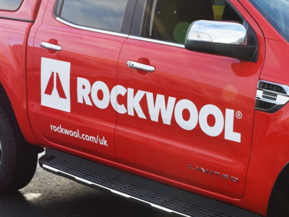 Business branded vinyl graphics on red SUV.