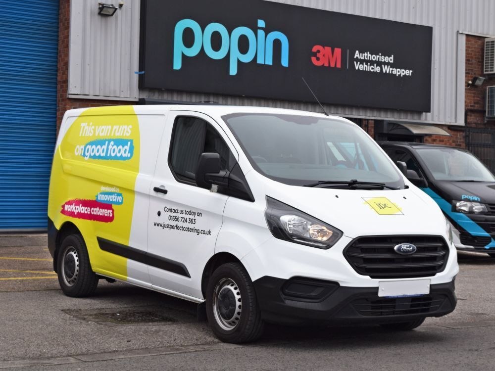 Partial vehicle wrap on a company white Ford Transit Custom van.