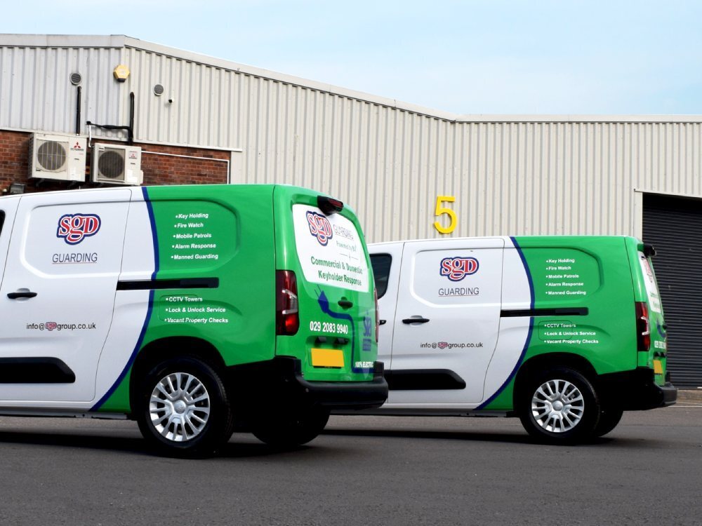 Green partial van wraps on rear of two Toyota Proace company electric vehicles.