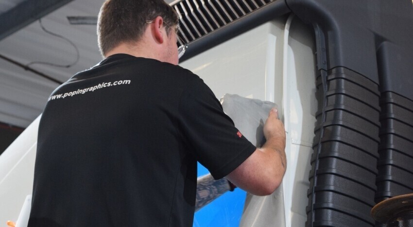 Vehicle wrap installer working on a GMC lorry at Popin in Cardiff.