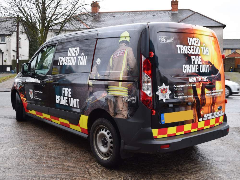 Full vehicle wrap and chevron safety vinyl graphics installed on Ford Transit Connect emergency vehicle.