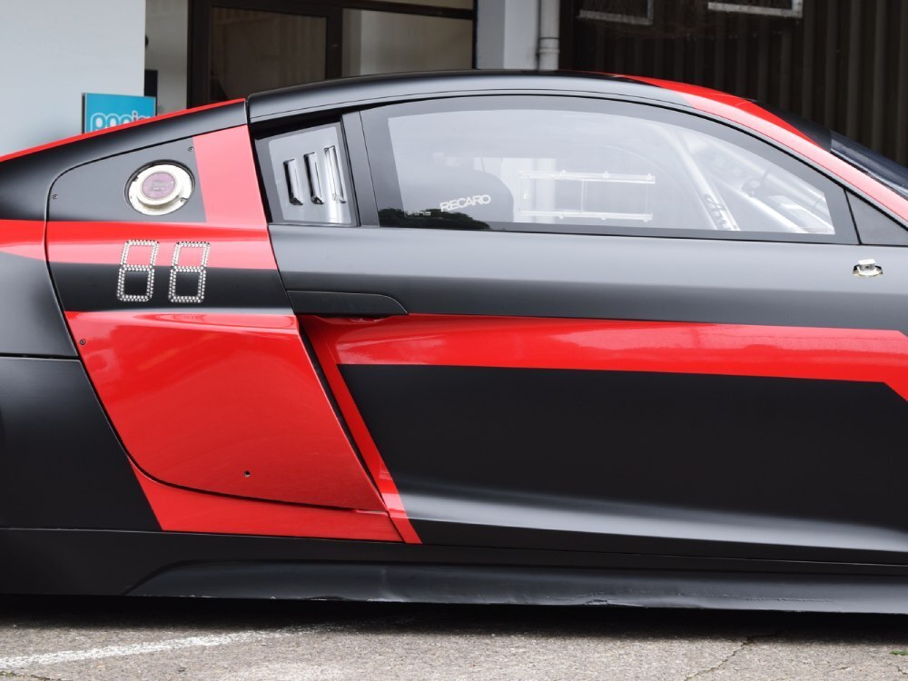 Close up of black and red wrap on company Audi R8 LMS.