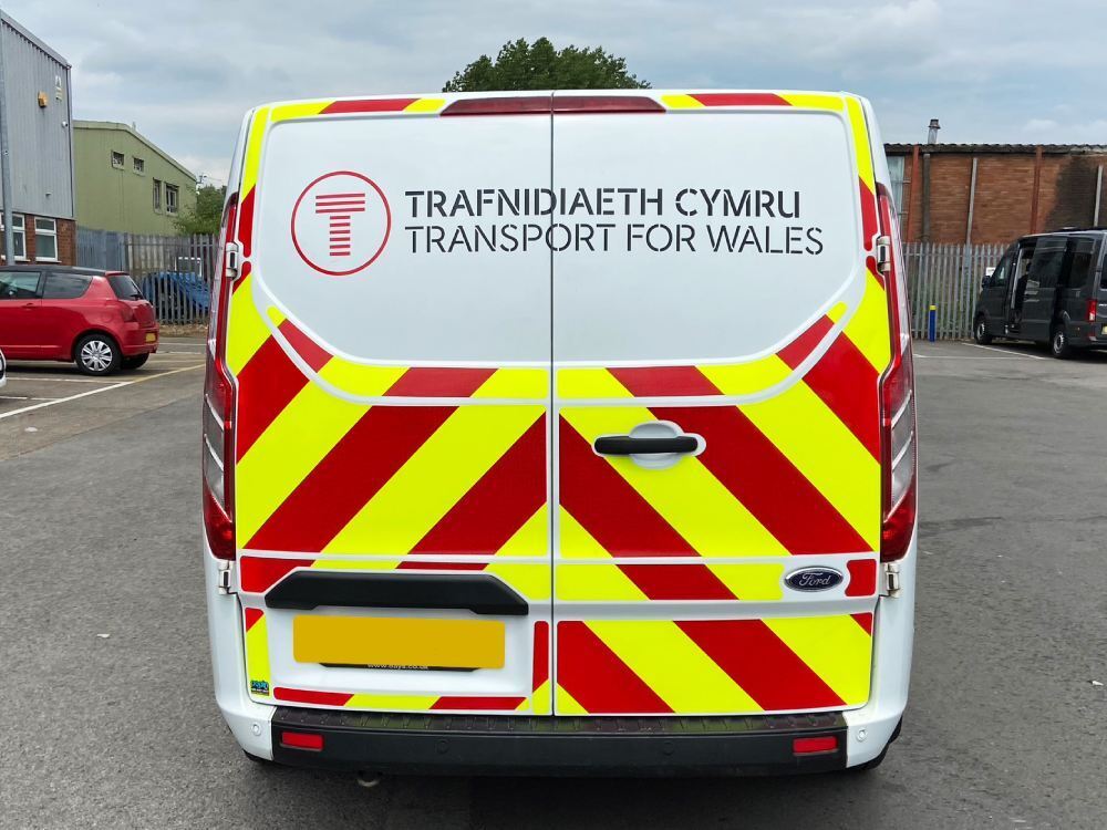 Chapter 8 chevron safety marking vinyl graphics installed on rear of white Ford Transit Custom van.